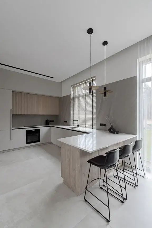  Modern L shaped kitchen with island seating, beige cabinets, and contemporary pendant lights.