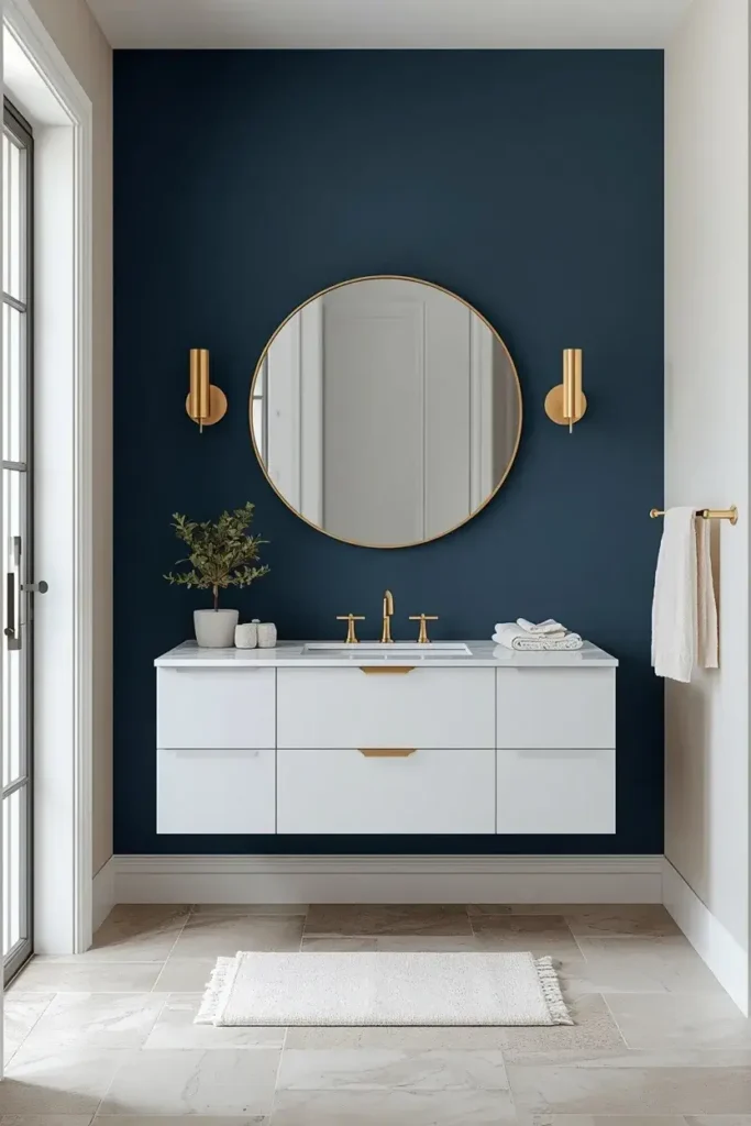 Modern bathroom with a deep blue statement wall behind a white floating vanity.