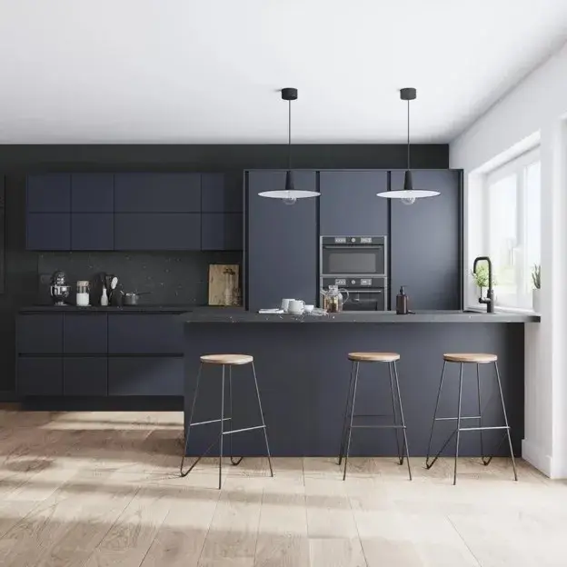 Modern kitchen featuring matte dark blue cabinets, light stone countertops, and understated hardware.