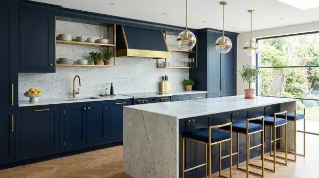 Navy kitchen cabinets with brushed brass handles, a brass faucet, and white marble countertops.