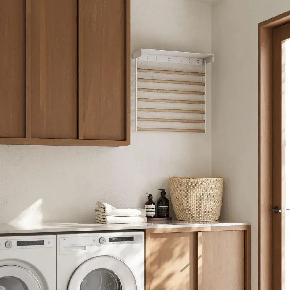 Small laundry room with a wall-mounted wooden drying rack above a countertop.