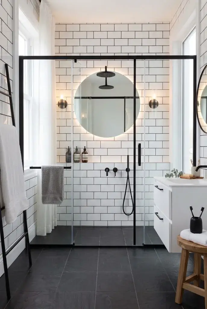 White bathroom with matte black faucets, shower hardware, towel bars, and cabinet handles.