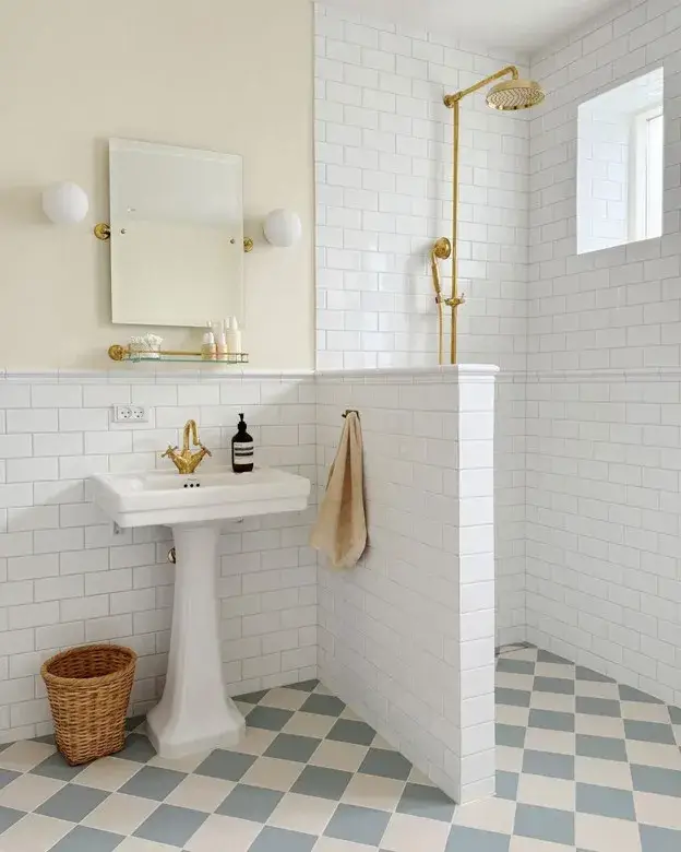 Light blue and white checkerboard bathroom floor with a white pedestal sink, vintage mirror, and classic chrome fixtures.