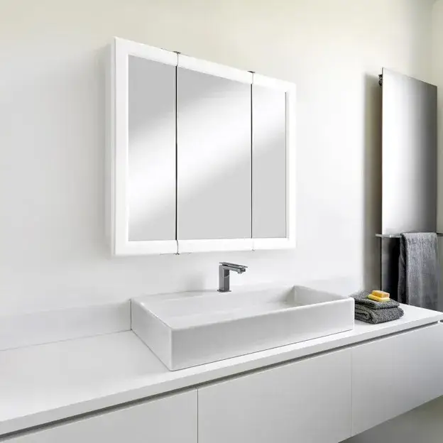 Modern mirrored bathroom cabinet above a sink with hidden storage and elegant LED lighting