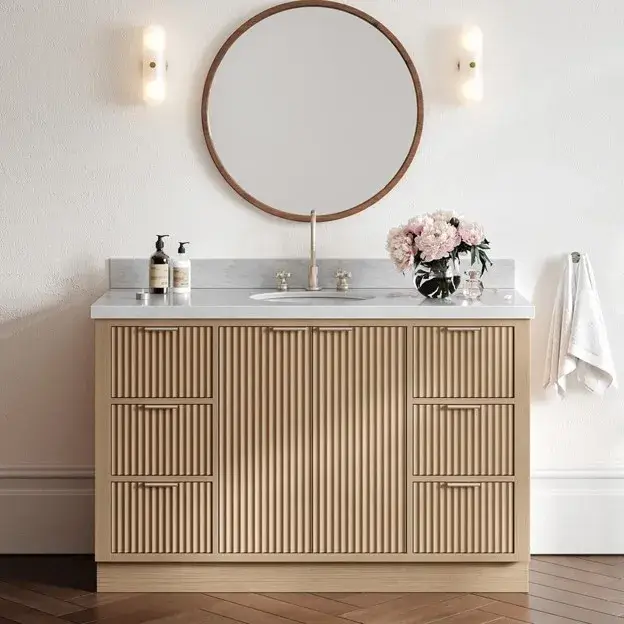 Beautiful modern bathroom cabinet with natural wood drawers, marble countertop, round mirror, and elegant neutral decor.